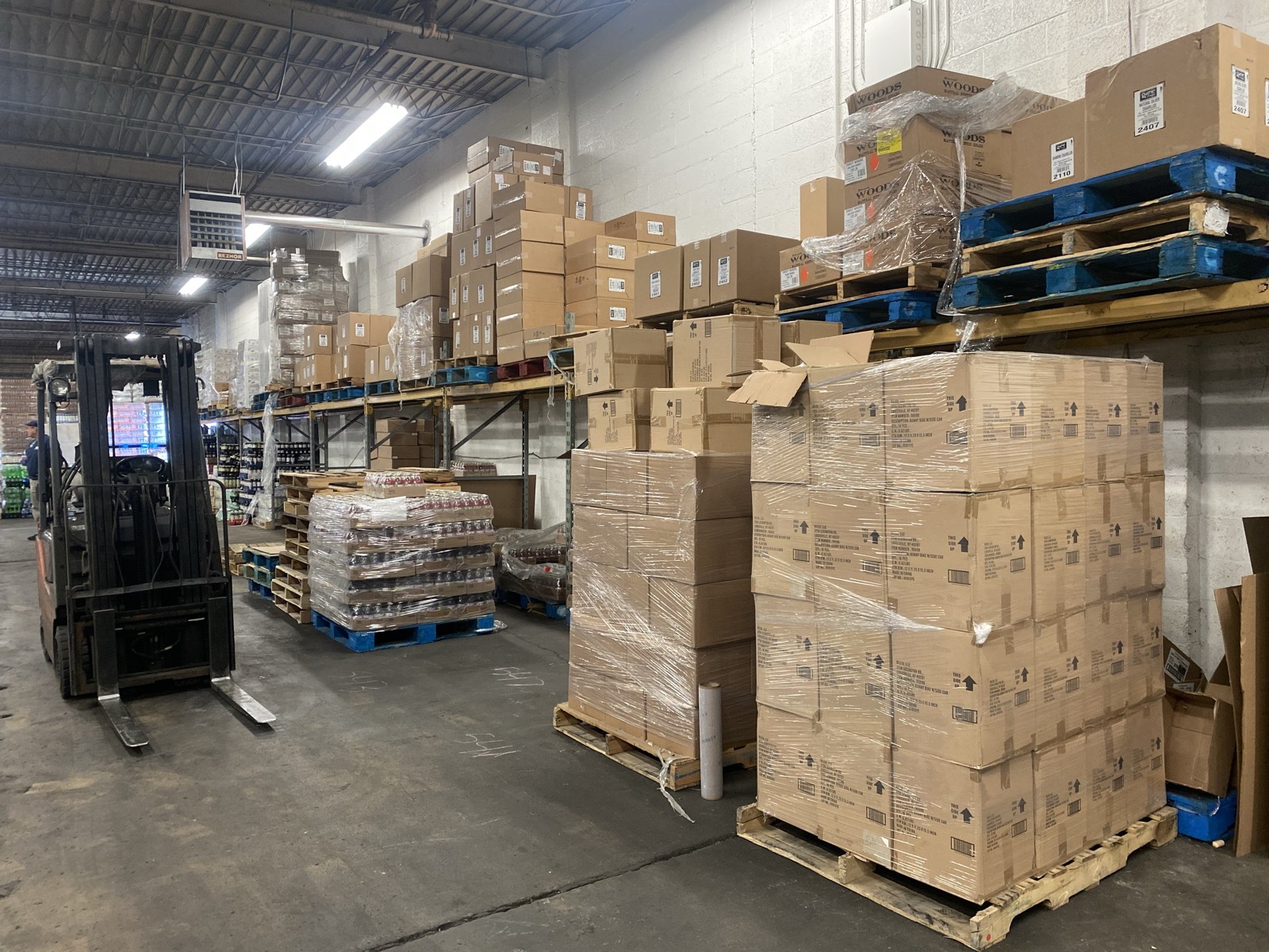 Forklift moving palletized inventory through the warehouse